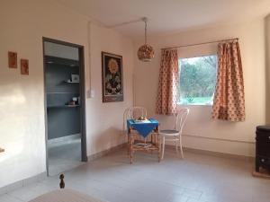 a dining room with a table and chairs and a window at Refugios del Alma in Villa Las Rosas