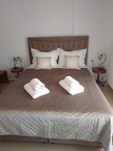 a large bed with two towels on top of it at Pepi Cozy in Alexandroupoli
