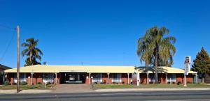 ウェスト・ワイアロングにあるCountry Roads Motor Innのヤシの木が並ぶ通りの角の建物