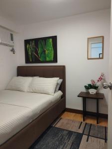 a bedroom with a bed and a side table at Homestay Arezzo Place Davao - Building 9 in Davao City