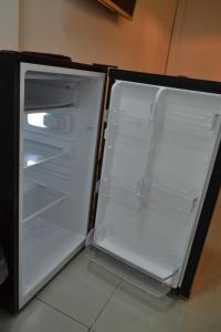 an empty refrigerator with its door open in a kitchen at Apartamento no coração de Petrópolis in Petrópolis