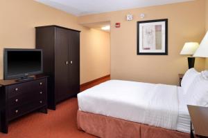 a hotel room with a bed and a flat screen tv at Holiday Inn Martinsburg, an IHG Hotel in Martinsburg