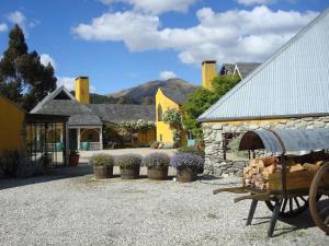 a stone building with flowers in pots in front of it at Arty Luxury Barn Apartment in Closeburn