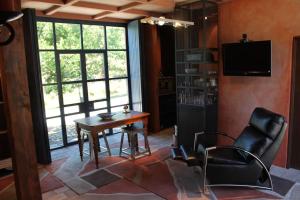 a living room with a table and chairs and a television at Arty Luxury Barn Apartment in Closeburn