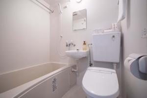 a white bathroom with a toilet and a sink at RESI STAY Yasaka in Kyoto