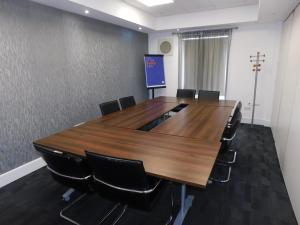 a conference room with a large wooden table and chairs at Holiday Inn Express Nuneaton by IHG in Nuneaton