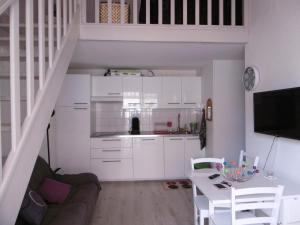 Una sala de estar con armarios blancos y una escalera. en Villa T2 Mezzanine 5 pers, Clim, Terrasse, Parking, Proche plage et commerces - FR-1-795-16, en Fleury 13 fotos más