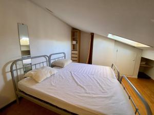 a bedroom with a white bed in a attic at Pavillon T2 Mezzanine - Climatisation - Véranda - Parking - Piscine - 6 Pers - FR-1-795-40 in Fleury