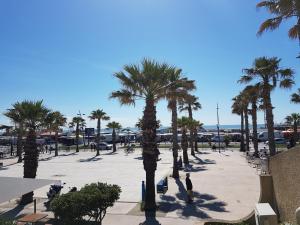 a man standing in a parking lot with palm trees at Pavillon T2 Mezzanine - Climatisation - Véranda - Parking - Piscine - 6 Pers - FR-1-795-40 in Fleury
