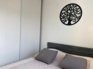 a bedroom with a bed and a clock on the wall at Saint-Pierre-La-Mer : Appart T2 avec Piscine, Parking, Clim, Terrasse - 4 Pers. - FR-1-795-26 in Fleury