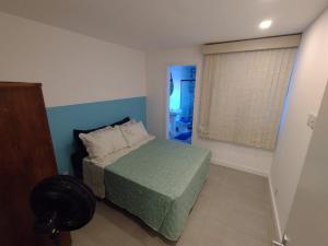 a small bedroom with a bed and a window at Apartamento no coração de Petrópolis in Petrópolis