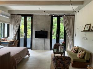 a bedroom with a bed and a couch and a tv at 泰森會館 in Lugu Lake