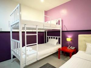a bedroom with two bunk beds and a red table at Donmueang Airport Modern bangkok in Ban Ko