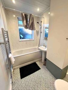a bathroom with a tub and a sink and a toilet at Gorgeous Spacious 2 Br Home 10 Mins To City in Gateshead