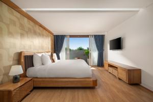 a bedroom with a large bed and a television at Mixay Boutique Hotel Da Nang in Danang