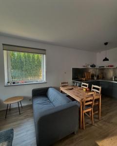 a living room with a blue couch and a table at Corner House Plesna in Pleśna