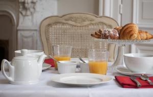 uma mesa com um pequeno-almoço de croissants e sumo de laranja em Maison M Troyes em Troyes