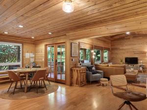 ein Wohnzimmer mit einer Couch und einem Tisch und Stühlen in der Unterkunft Woods Waves: Luxury Coast Cabin King Beds Pets in Tillamook