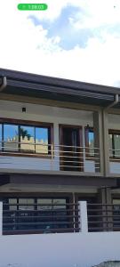 a house with a balcony with a view of the ocean at Pacifico's Hostel in Barili