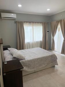 a bedroom with a bed and a large window at Alojamiento la irene in Paso de la Patria +30 photos