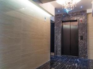 a elevator lobby with a black door and a chandelier at Metroplace Boutique in Hong Kong