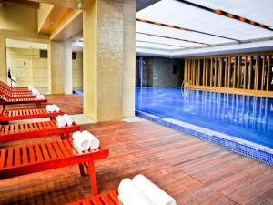 une piscine avec des bancs rouges à côté d'une piscine dans l'établissement Chengdu Joyhub Air Hotel, à Chengdu