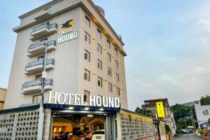 顺天市Suncheon Hound Hotel Suncheon Station Branch的一座酒店大楼，楼顶有招牌