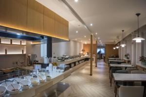 a large kitchen with tables and chairs in a restaurant at Gotel Capital in Beijing