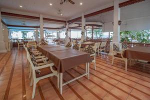 a dining room with tables and chairs and windows at Privacy Beach Resort & Spa in Ban Nong Khao Nieo