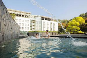 a woman and child playing in a swimming pool at Padma Hotel Bandung in Bandung