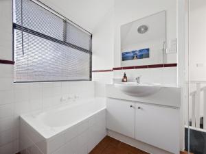 Un baño blanco con bañera y lavabo. en Riverside Margaret River, en Margaret River Town 15 fotos más