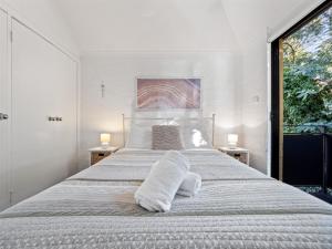 Un dormitorio blanco con una cama grande con toallas. en Riverside Margaret River, en Margaret River Town