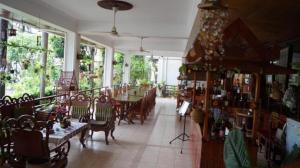 a dining room with tables and chairs and windows at Champa Residence Hotel in Pakse
