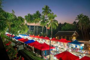 a market with many red and blue tents and palm trees at Saysamphanh Hotel in Ban Nongkham