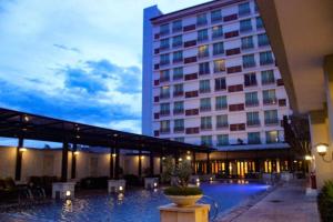 a hotel with a swimming pool in front of a building at Grand Surya Hotel Kediri in Kediri
