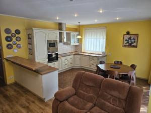 a kitchen and living room with a couch and a table at Vila Elegancija in Palanga