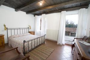 sypialnia z łóżkiem i dużym oknem w obiekcie Agriturismo Il Torrione w mieście Pinerolo