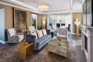 a living room with a couch and chairs and a fireplace at The Windsor Court in New Orleans