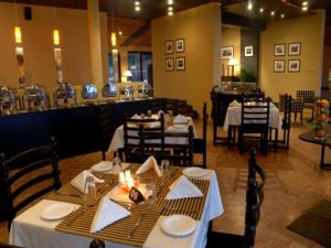 a dining room with tables and chairs and a restaurant at The Lake Hotel in Polonnaruwa