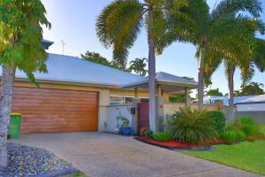 a house with palm trees in front of it at Private Luxury Haven with SUV Hire, Pool, Near Marina in Trinity Beach