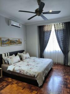 a bedroom with a bed with a ceiling fan at Hening Kesuma Homestay in Beranang