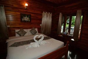 una camera da letto con un letto con un cigno bianco sopra di Srisawat Resort a Hua Hin Altre 123 foto