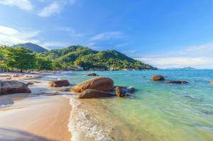 a beach with some rocks in the water at Timeless Hostel in Chaweng Noi Beach