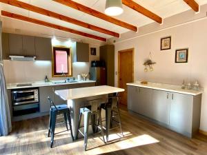 eine große Küche mit Tisch und Stühlen in der Unterkunft Cabañas Los Abetos in Puerto Varas