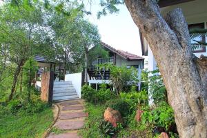 a house with a walkway in front of a house at Baan Suan Nuan Ta in Samut Songkhram