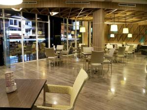 a dining room with tables and chairs in a building at Orchardz Hotel Gajah Mada in Pontianak