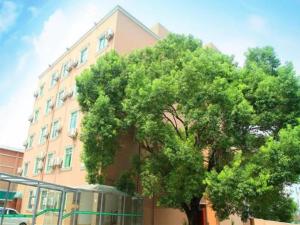 ein großer Baum vor einem Gebäude in der Unterkunft GreenTree Inn Shenzhen Kengzi Town Express Hotel in Kengzi