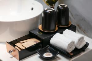 a bathroom with two black towels on a table at Acoustic Premium Hotel & Spa in Hanoi +39 photos