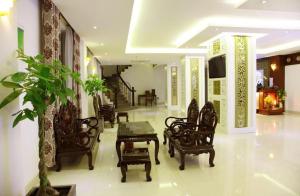 a lobby with chairs and a table and a plant at Rain Bow Hotel in Ho Chi Minh City +21 photos
