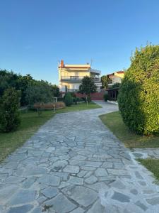 a stone path in a park with a building in the background at Villa Constanza in Siviri